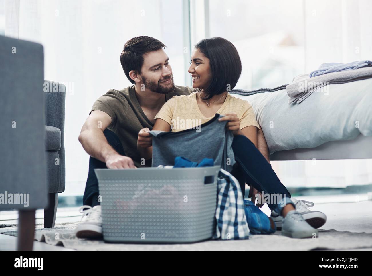 Si je ne le dis pas assez souvent, je vous apprécie. Photo d'un jeune couple heureux faisant le linge ensemble à la maison. Banque D'Images