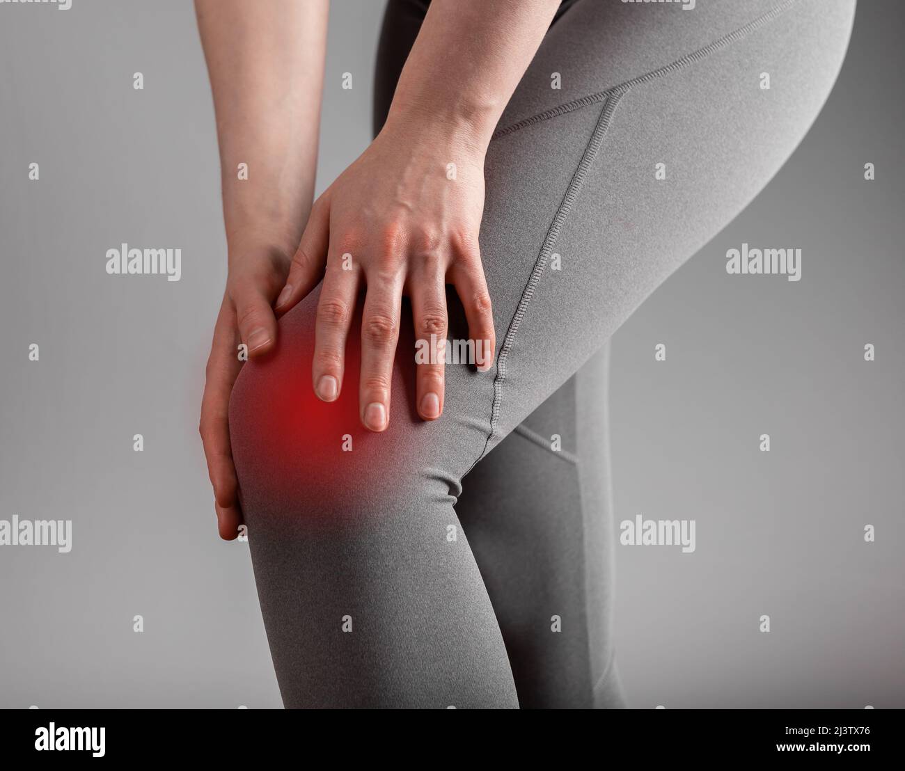 Douleurs au genou. Femme tenant une jambe douloureuse avec un spot rouge en gros plan. Arthrite, tendinite, entorses ou ligaments tendus conséquences. Soins de santé, problèmes orthopédiques et concept de médecine. Photo Banque D'Images