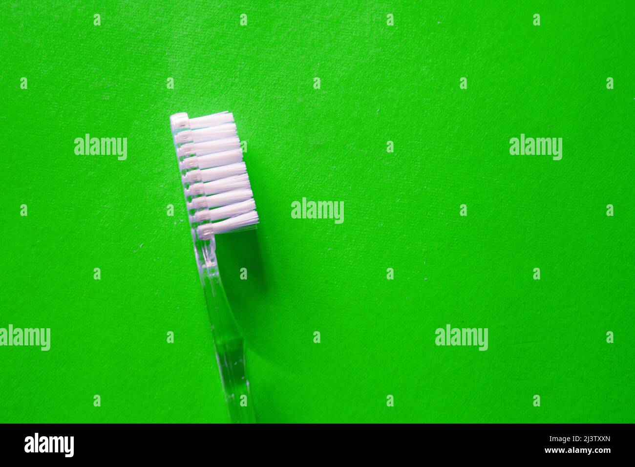 Brosse à dents transparente sur fond vert avec espace de copie Banque D'Images