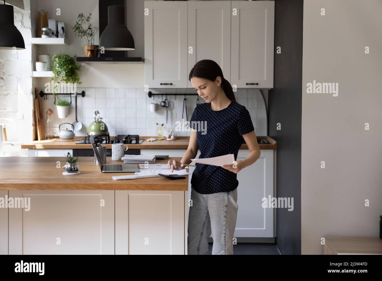 Une jeune femme gère les factures de paiement du budget familial à l'aide de l'application e-Bank Banque D'Images