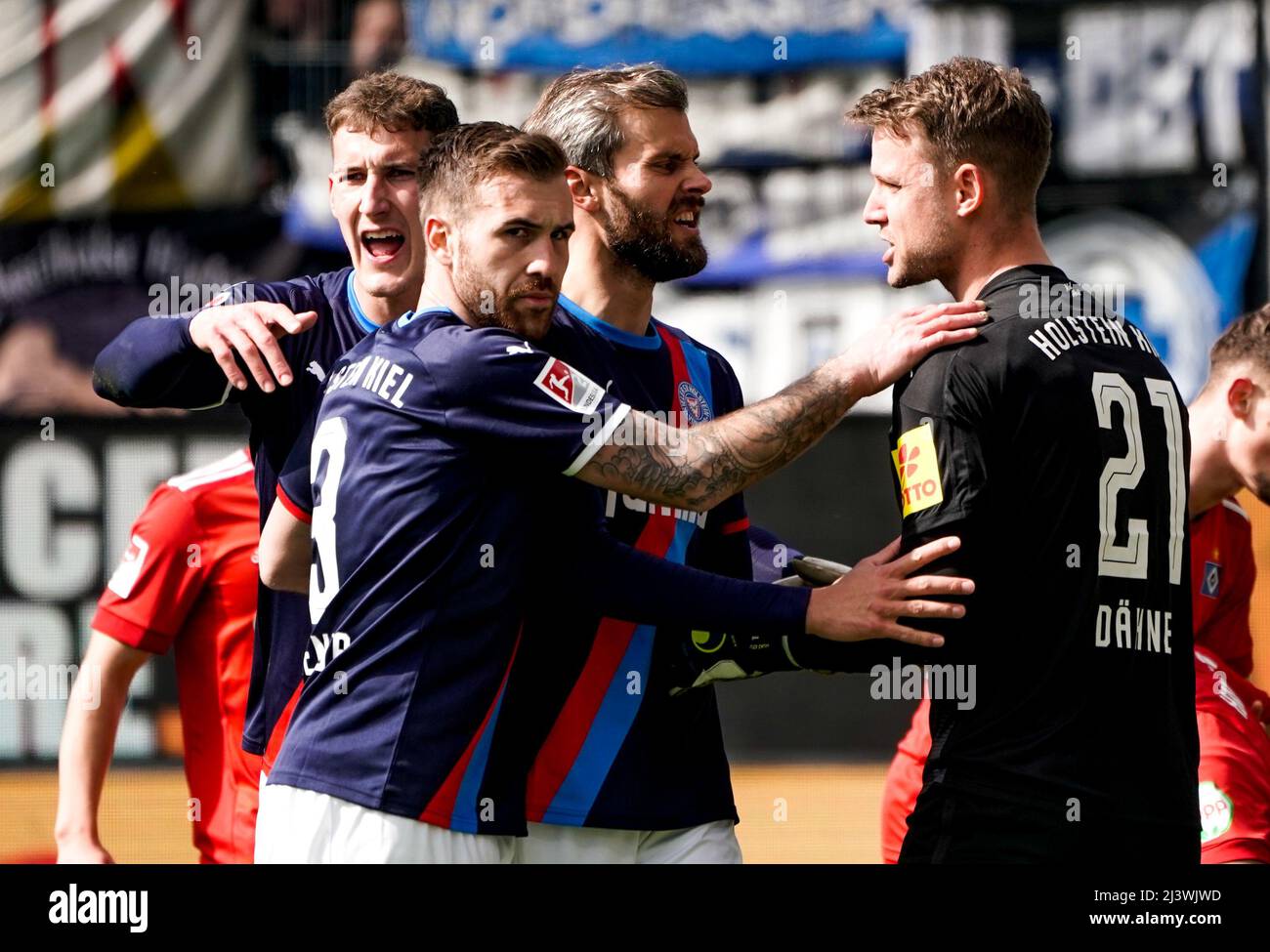 Kiel, Allemagne. 10th avril 2022. Football: 2nd Bundesliga, Holstein Kiel - Hamburger SV, Matchday 29, stade Holstein. Phil Neumann (l-r) de Kiel, Marco Komenda de Kiel et Stefan Thesker de Kiel célèbrent le gardien de but Thomas Dähne de Kiel pour un bal tenu. Crédit : Axel Heimken/dpa - REMARQUE IMPORTANTE : Conformément aux exigences de la DFL Deutsche Fußball Liga et de la DFB Deutscher Fußball-Bund, il est interdit d'utiliser ou d'avoir utilisé des photos prises dans le stade et/ou du match sous forme de séquences et/ou de séries de photos de type vidéo./dpa/Alay Live News Banque D'Images