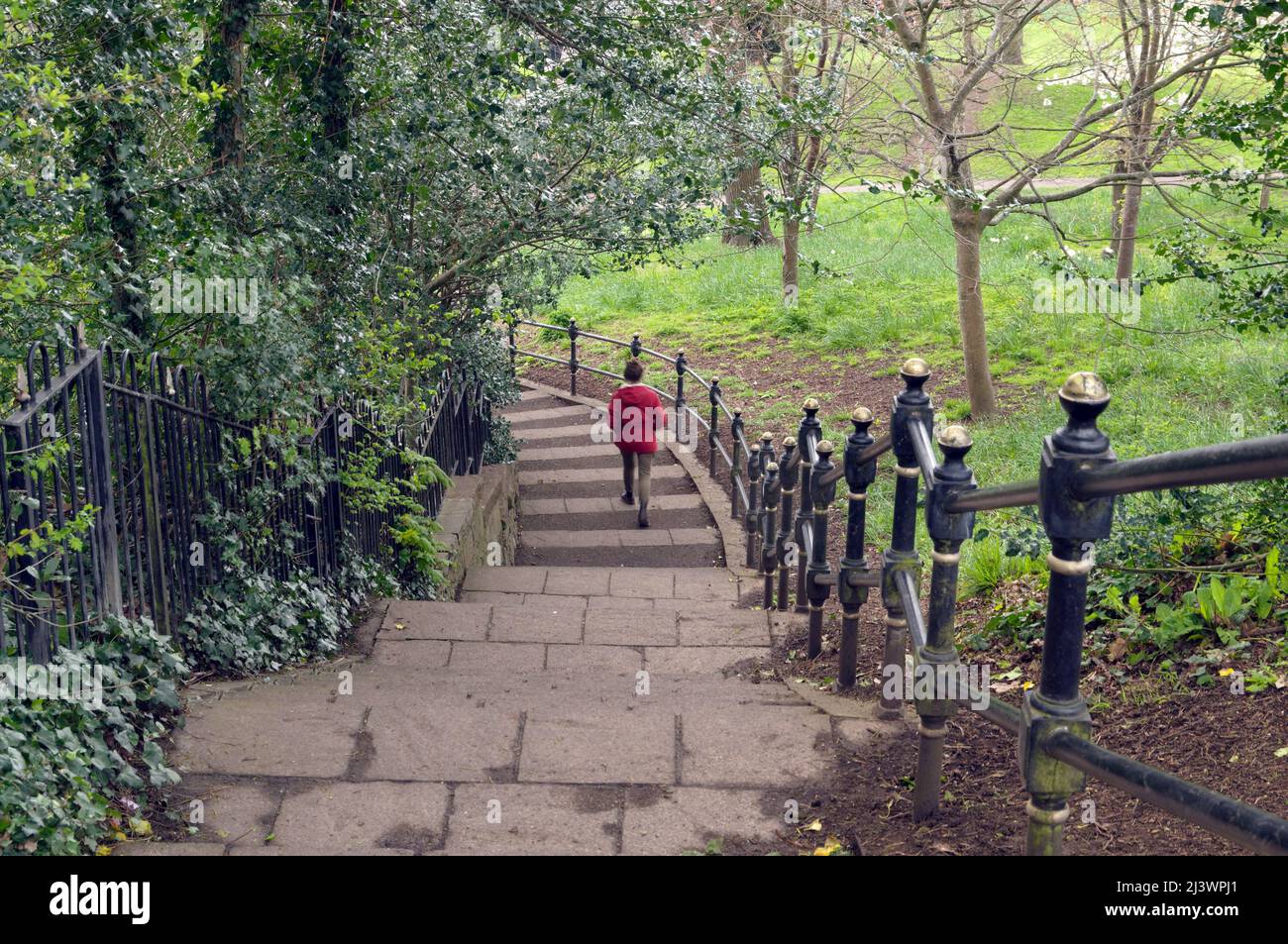 Regardant en bas une femme en veste rouge marchant sur les marches de Thompson's Park, Romilly Road Cardiff Banque D'Images