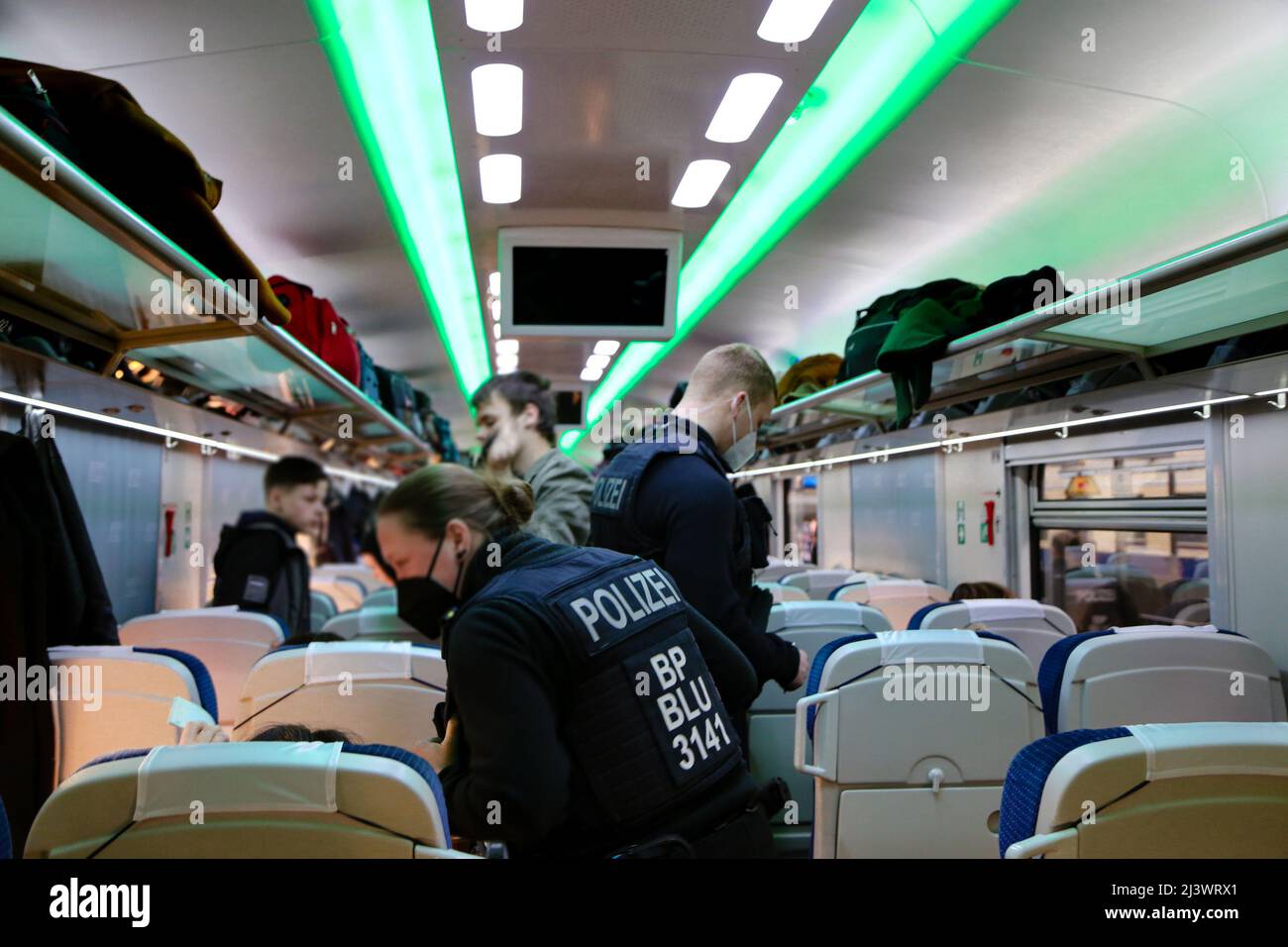Frontière germano-polonaise : contrôle des frontières dans un train de réfugiés avec des réfugiés ukrainiens. Les passeports sont contrôlés par la police allemande. Banque D'Images
