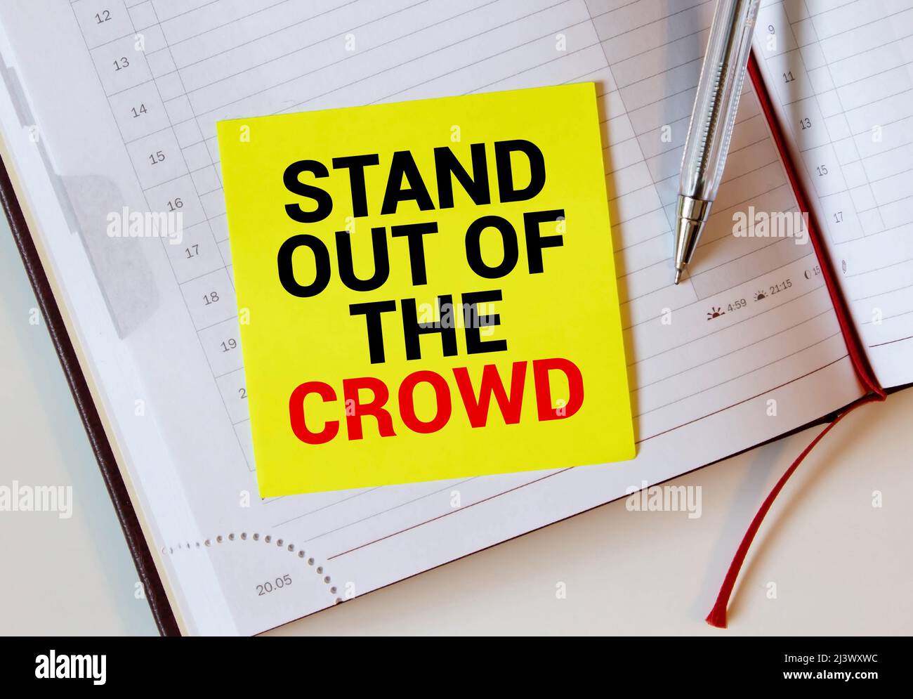 Les mots sortent de la foule écrits sur un cahier blanc.Gros plan d'un agenda personnel. Banque D'Images