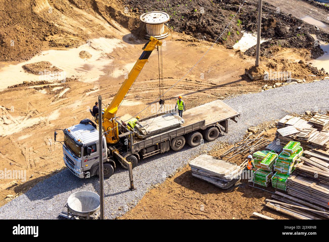 Kemerovo, Russie - 24 juin 2021. Un camion surdimensionné doté d'une plate-forme de chargement étendue et d'une grue pour le chargement et le déchargement de marchandises se trouve sur un c Banque D'Images