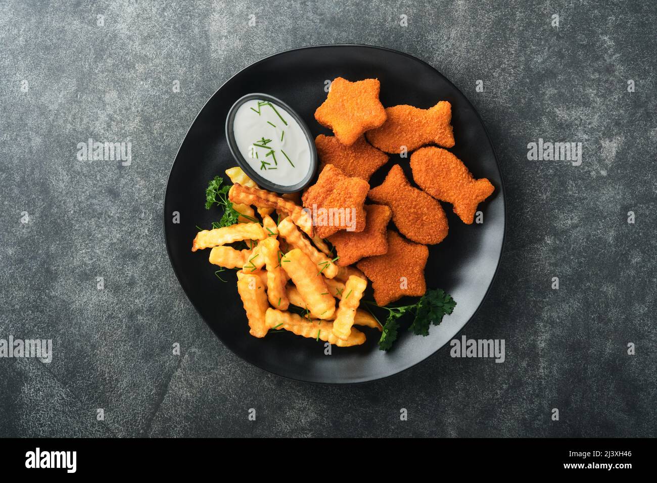 Fish Chips, restauration rapide britannique. Bâtonnets de poisson avec frites sur plaque noire sur fond de table noire. Cuisine traditionnelle britannique authentique ou Banque D'Images