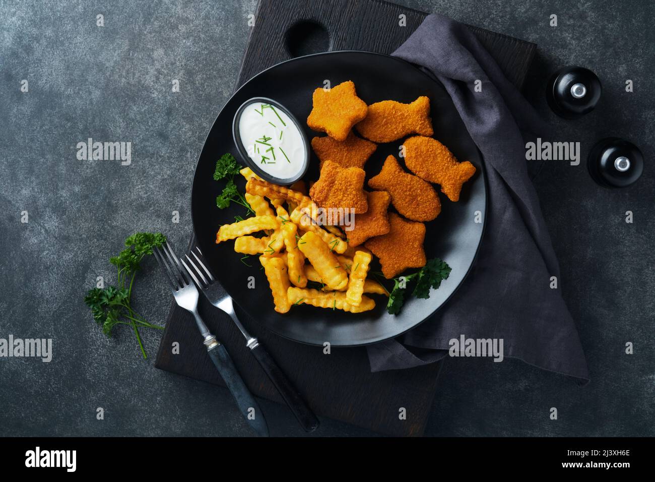 Fish Chips, restauration rapide britannique. Bâtonnets de poisson avec frites sur plaque noire sur fond de table noire. Cuisine traditionnelle britannique authentique ou Banque D'Images