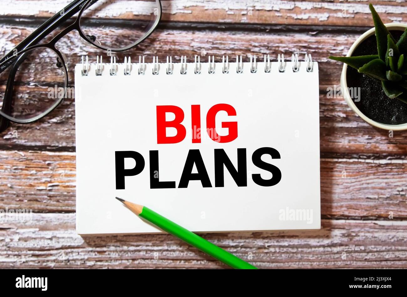 Schéma financier sur grand bloc-notes blanc, livre vert et feuille de papier avec texte GRAND PLAN Banque D'Images