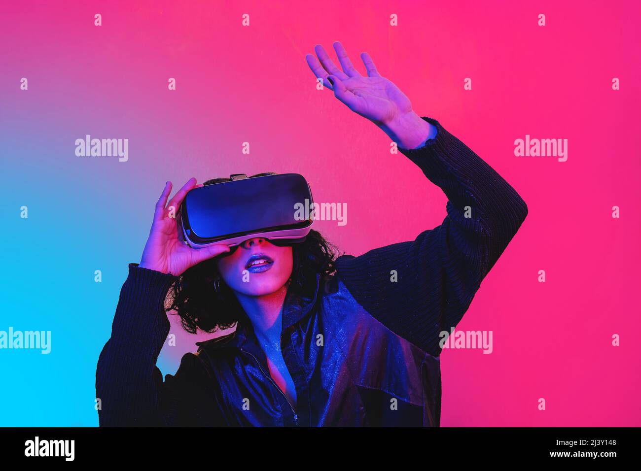 La jeune femme utilise le visualiseur de réalité virtuelle. Portrait de femme moderne avec un look tendance et des couleurs vives. Banque D'Images