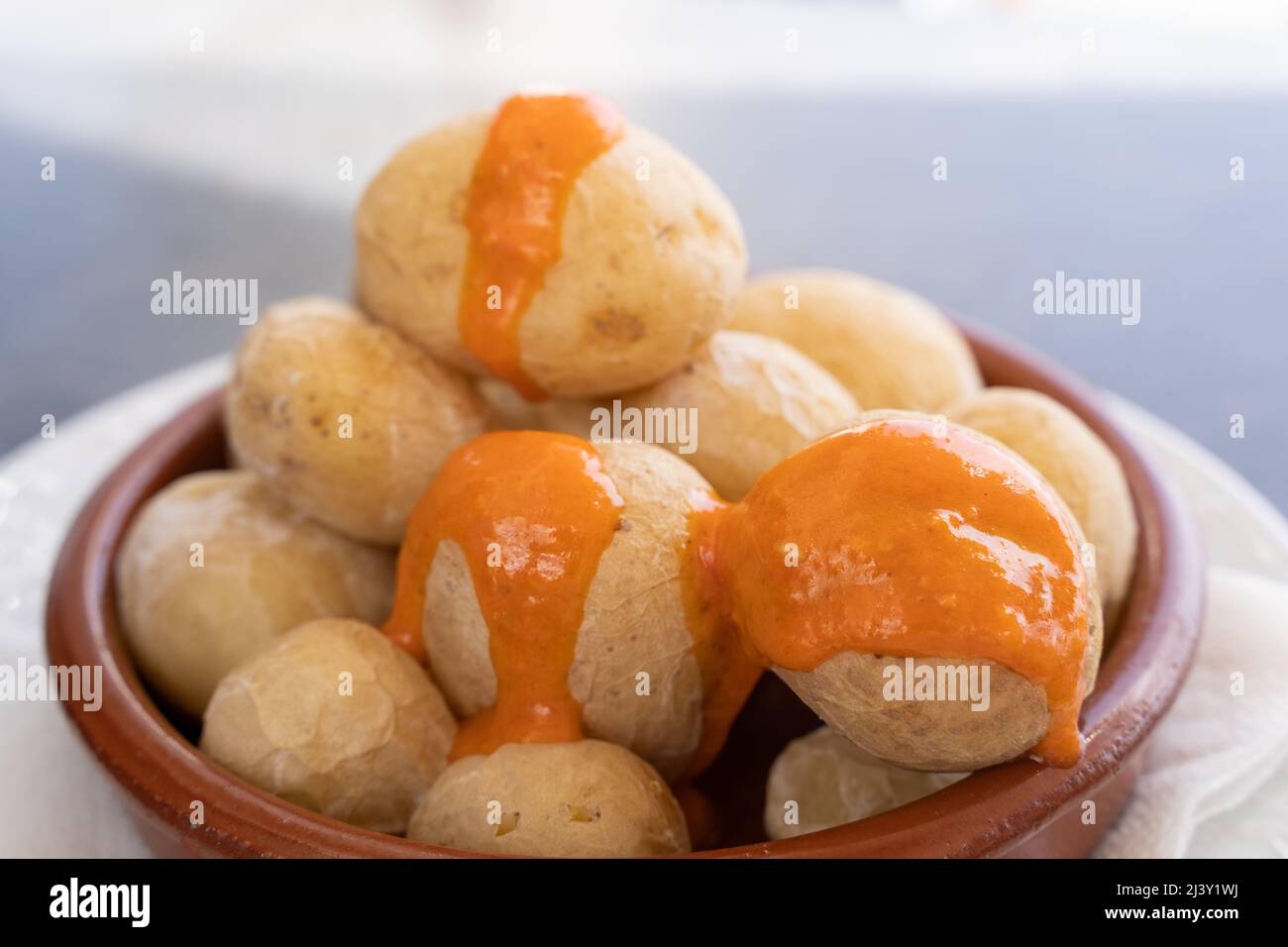 Papas arrugadas en plaque d'argile et sauce piquante au mojo sur le dessus. En-cas de pommes de terre ridées traditionnelles de l'île de Gran Canaria, Espagne Banque D'Images