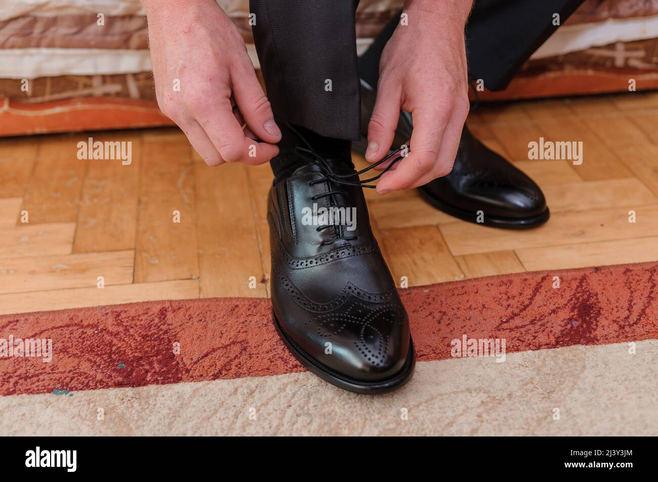 Homme nouant des lacets sur des chaussures en cuir Banque D'Images
