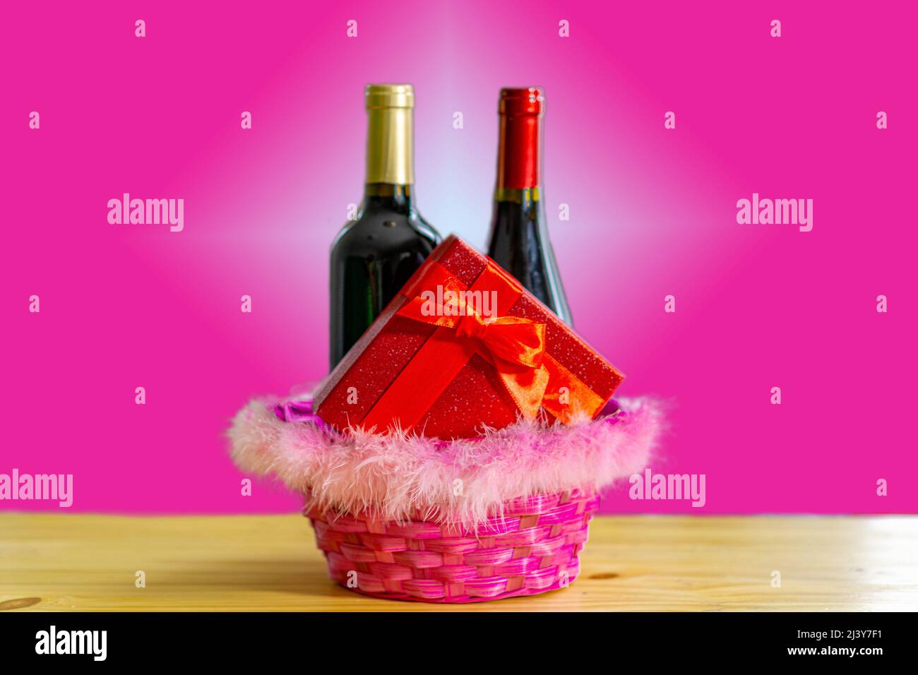 Boîte cadeau avec deux bouteilles de vin dans un panier de pâques. Un moment de surprise pour célébrer l'amour Banque D'Images
