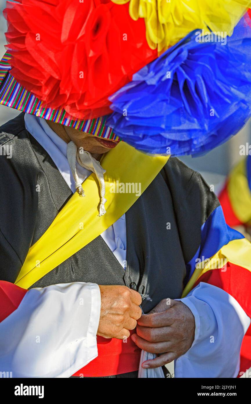 Batteur coréen traditionnel qui ajuste son costume coloré pour un spectacle Banque D'Images