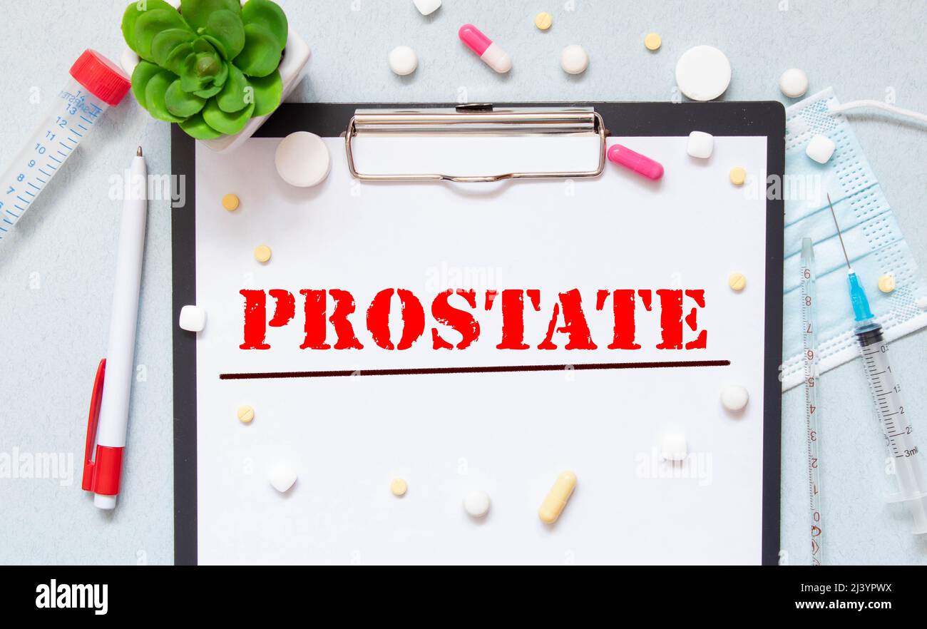 Bloc-notes blanc avec les mots cancer de la prostate et un stéthoscope sur fond bleu. Concept médical. Banque D'Images