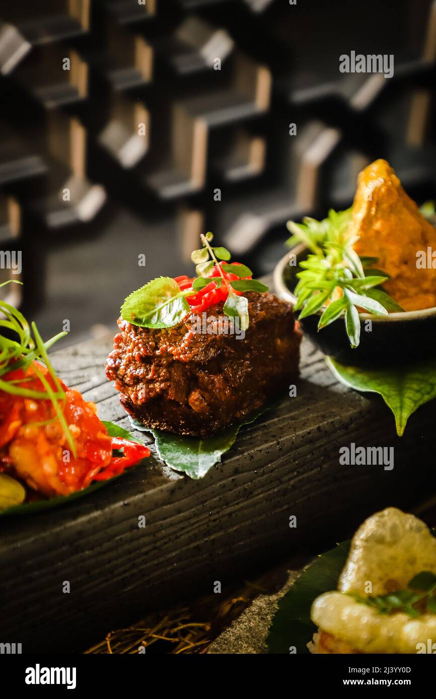 Bœuf Rendang dans un style de haute cuisine, entre autres plats padangnois Banque D'Images
