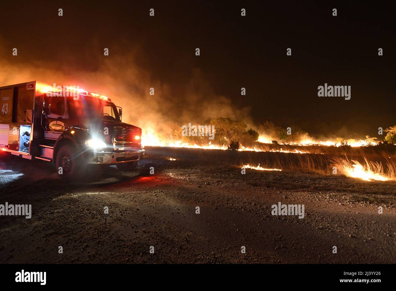 Un camion d'incendie de la US Air Force réagit à un grand feu de forêt le 9 avril 2022 à la base commune de San Antonio - zone de démolition de Camp Bullis. JBSA-Camp Bullis comprend plus de 27 000 hectares de champs de tir, de zones d’entraînement et de terres sauvages du côté nord de San Antonio et est un lieu d’entraînement crucial pour les membres de la base conjointe de San Antonio. (É.-U. Photo de la Force aérienne par Brian Boisvert) Banque D'Images