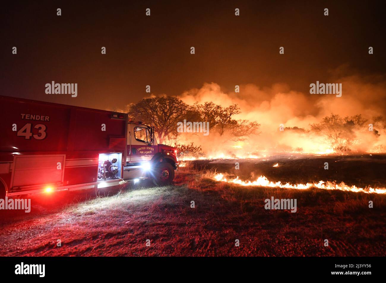 Un camion d'incendie de la US Air Force réagit à un grand feu de forêt le 9 avril 2022 à la base commune de San Antonio - zone de démolition de Camp Bullis. JBSA-Camp Bullis comprend plus de 27 000 hectares de champs de tir, de zones d’entraînement et de terres sauvages du côté nord de San Antonio et est un lieu d’entraînement crucial pour les membres de la base conjointe de San Antonio. (É.-U. Photo de la Force aérienne par Brian Boisvert) Banque D'Images