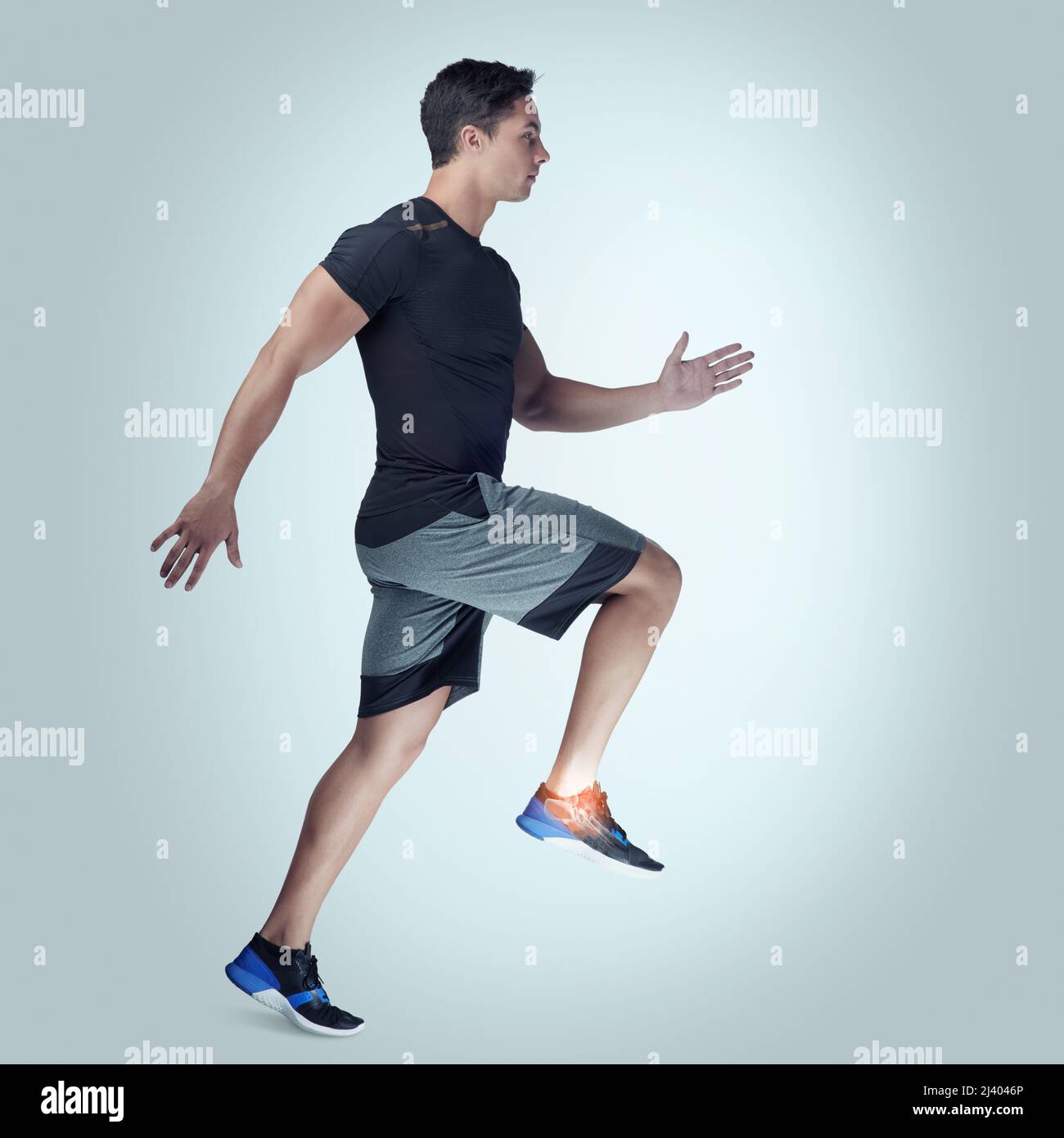 Gardez les limites de votre bodys à l'esprit. Photo en studio d'un jeune homme sportif qui court sur fond gris. Banque D'Images
