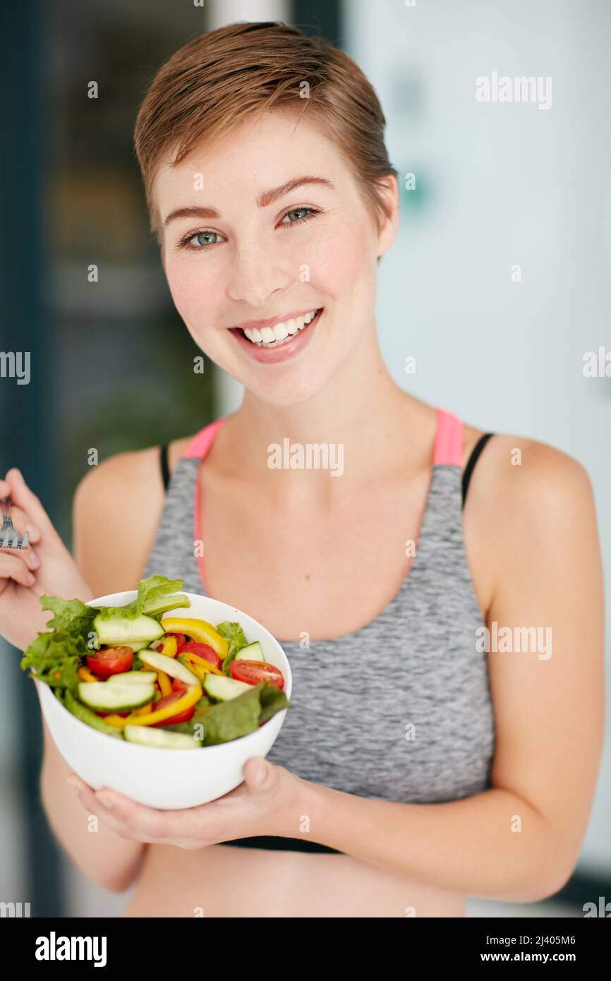 La santé est la meilleure décision que j'ai prise. Portrait d'une jeune femme en forme mangeant un bol de salade. Banque D'Images