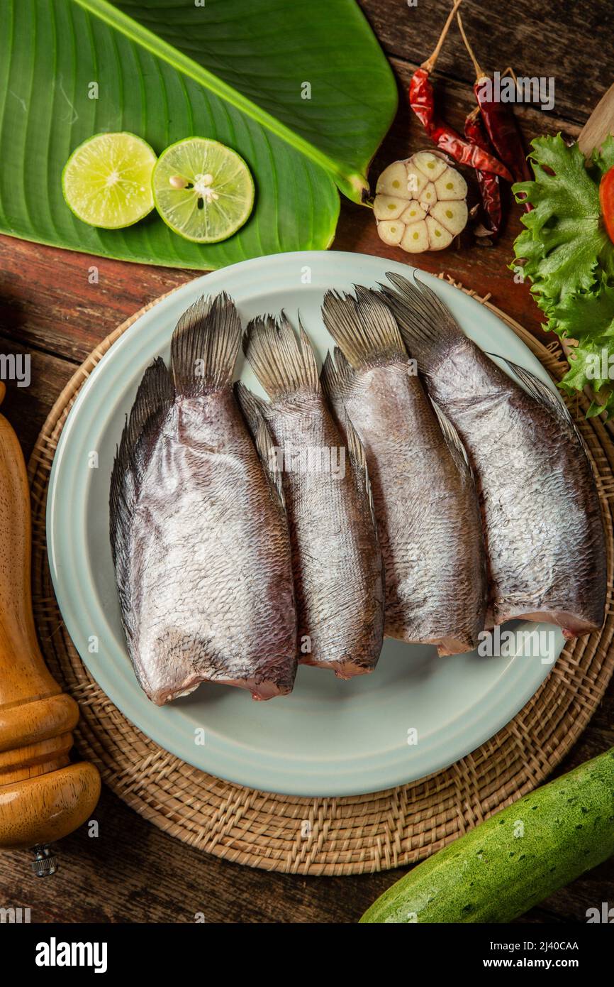 Poisson frais sur la table garni de légumes Banque D'Images