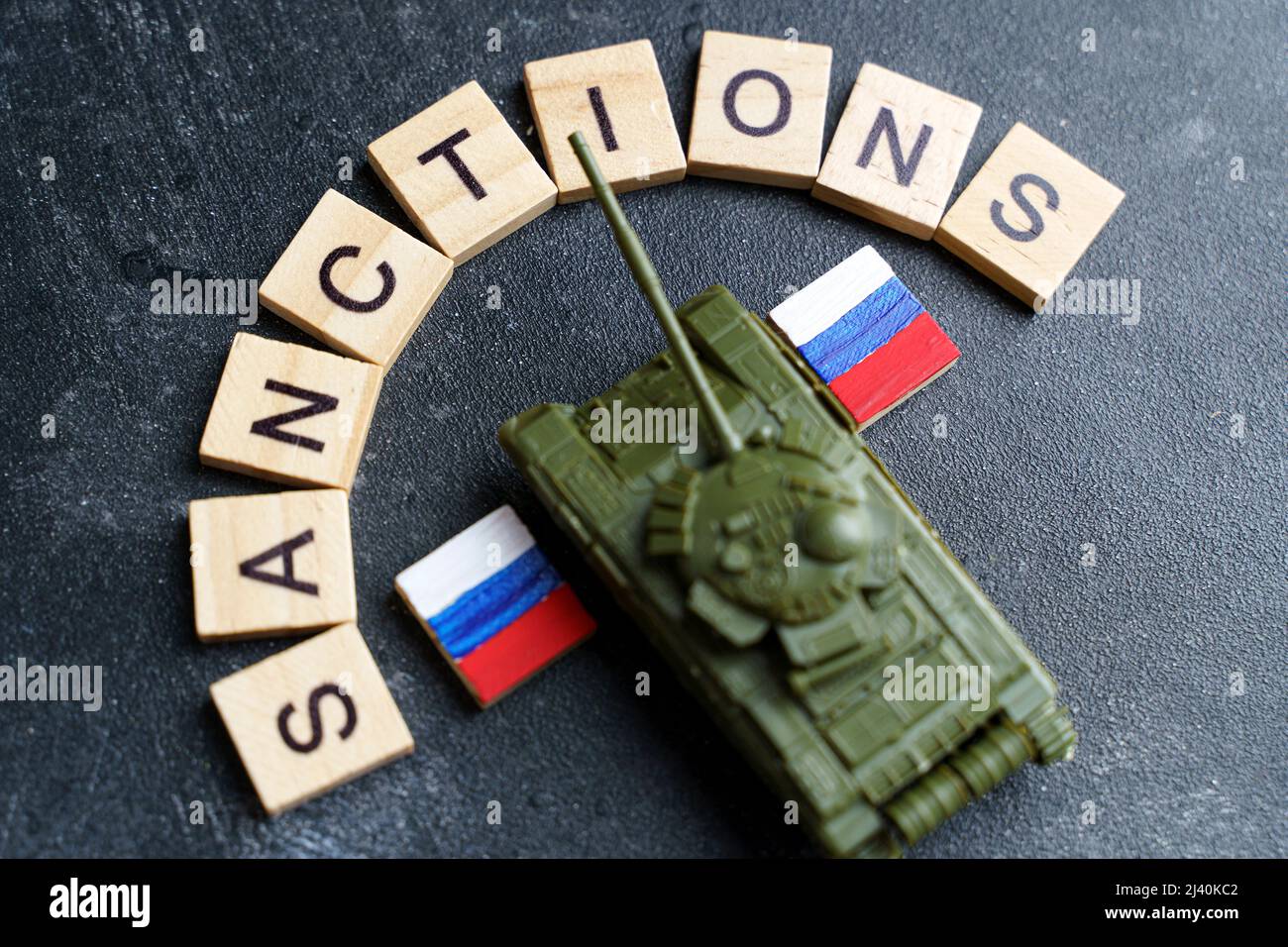 Concept de sanctions contre la Russie. Réservoir à jouets et inscription sanctions sur fond sombre. Conflit de guerre en Ukraine, défaut de paiement, crise économique et monétaire en Russie. Photo de haute qualité Banque D'Images