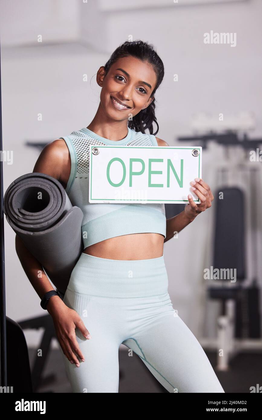 Vous aide à faire briller votre appareil. Portrait d'une jeune femme tenant un panneau ouvert dans sa salle de sport. Banque D'Images