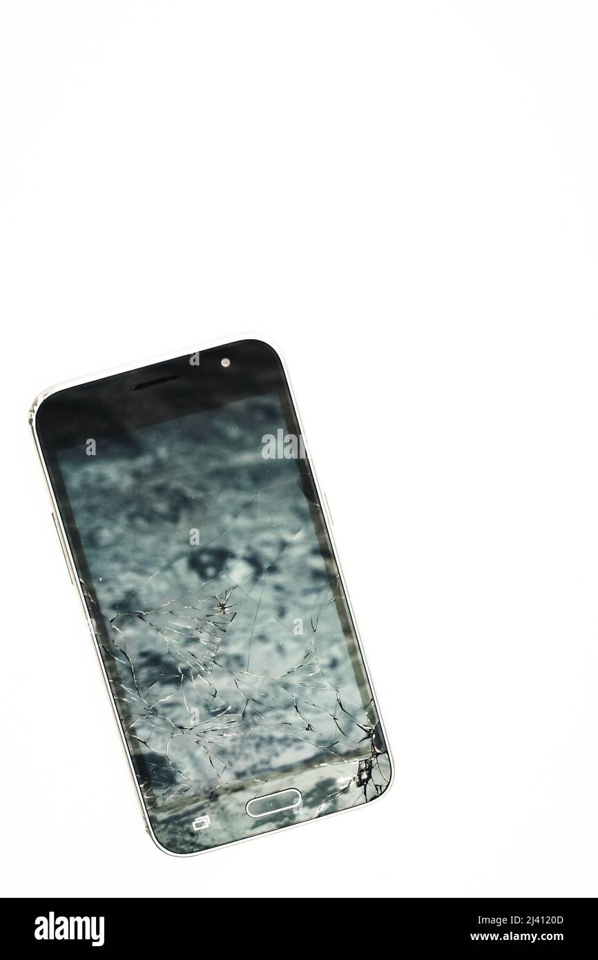 Téléphone cellulaire cassé sur fond blanc. Smartphone à écran tactile avec écran lcd fissuré. Banque D'Images