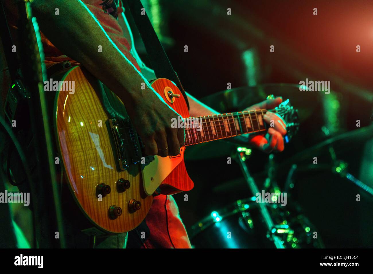Le guitariste joue la guitare sous les projecteurs. Mains d'un joueur de guitare jouant de la guitare. Mise au point sélective. Mise au point douce Banque D'Images