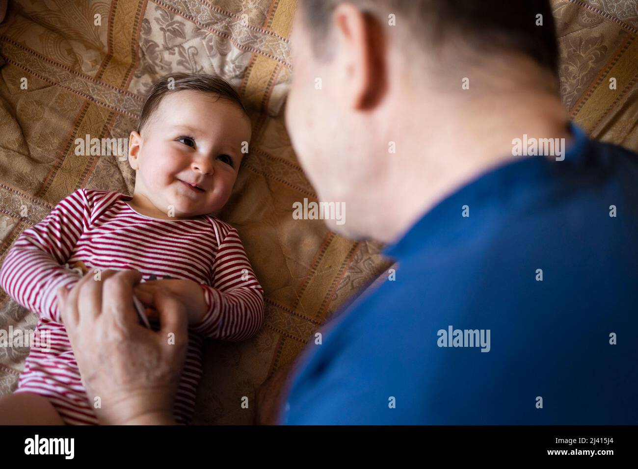 Petite-fille souriant et jouant avec son grand-père Banque D'Images