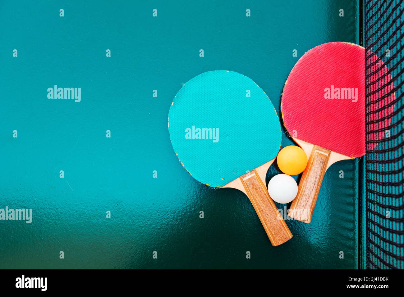 Raquettes de tennis de table et balles de ping-pong sur une surface de table verte avec filet, mise au point sélective Banque D'Images