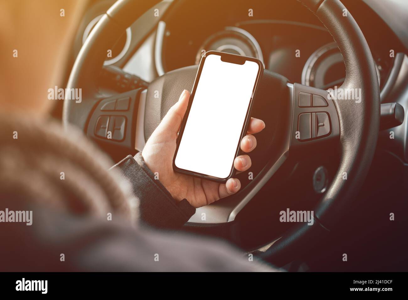 Smartphone Mockup écran blanc vierge en femme conducteur mains au-dessus du volant, mise au point sélective Banque D'Images