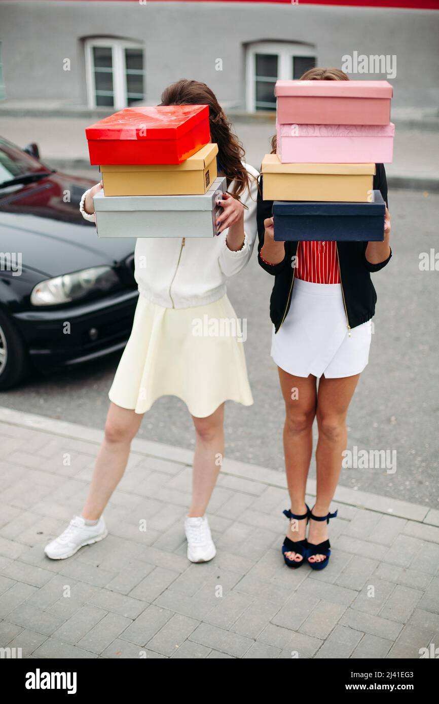 Incognito filles à la mode avec des piles de chaussures dans des boîtes  Photo Stock - Alamy