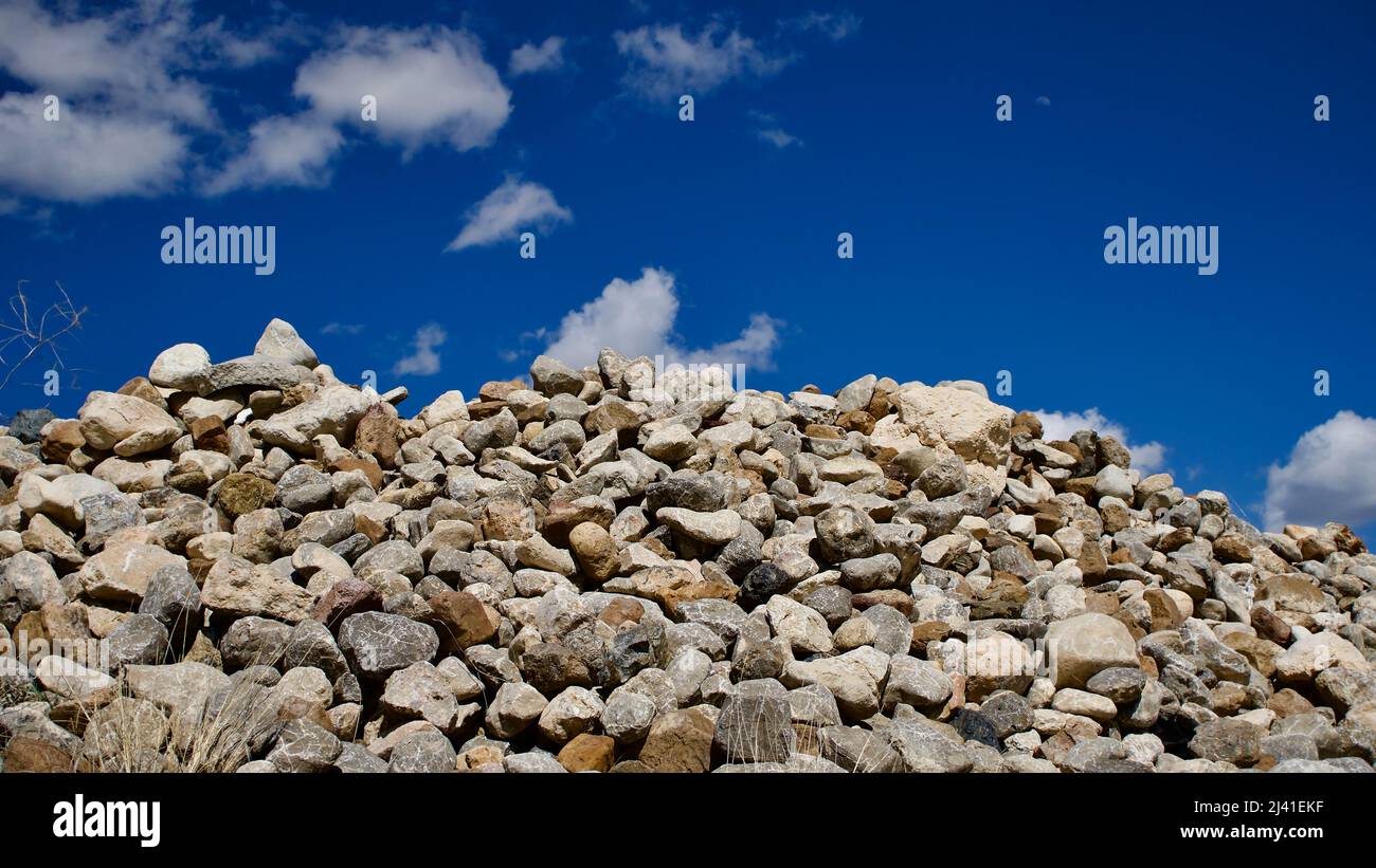 Pierres de diverses structures déposées sur le bord du champ. Tas de pierres de déchets. Banque D'Images
