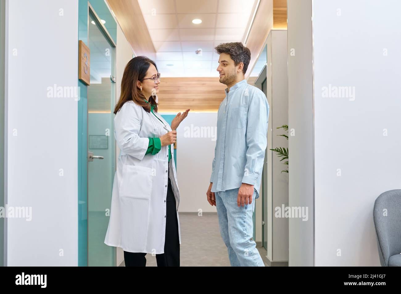 Femme médecin discutant de quelque chose avec un patient mâle Banque D'Images