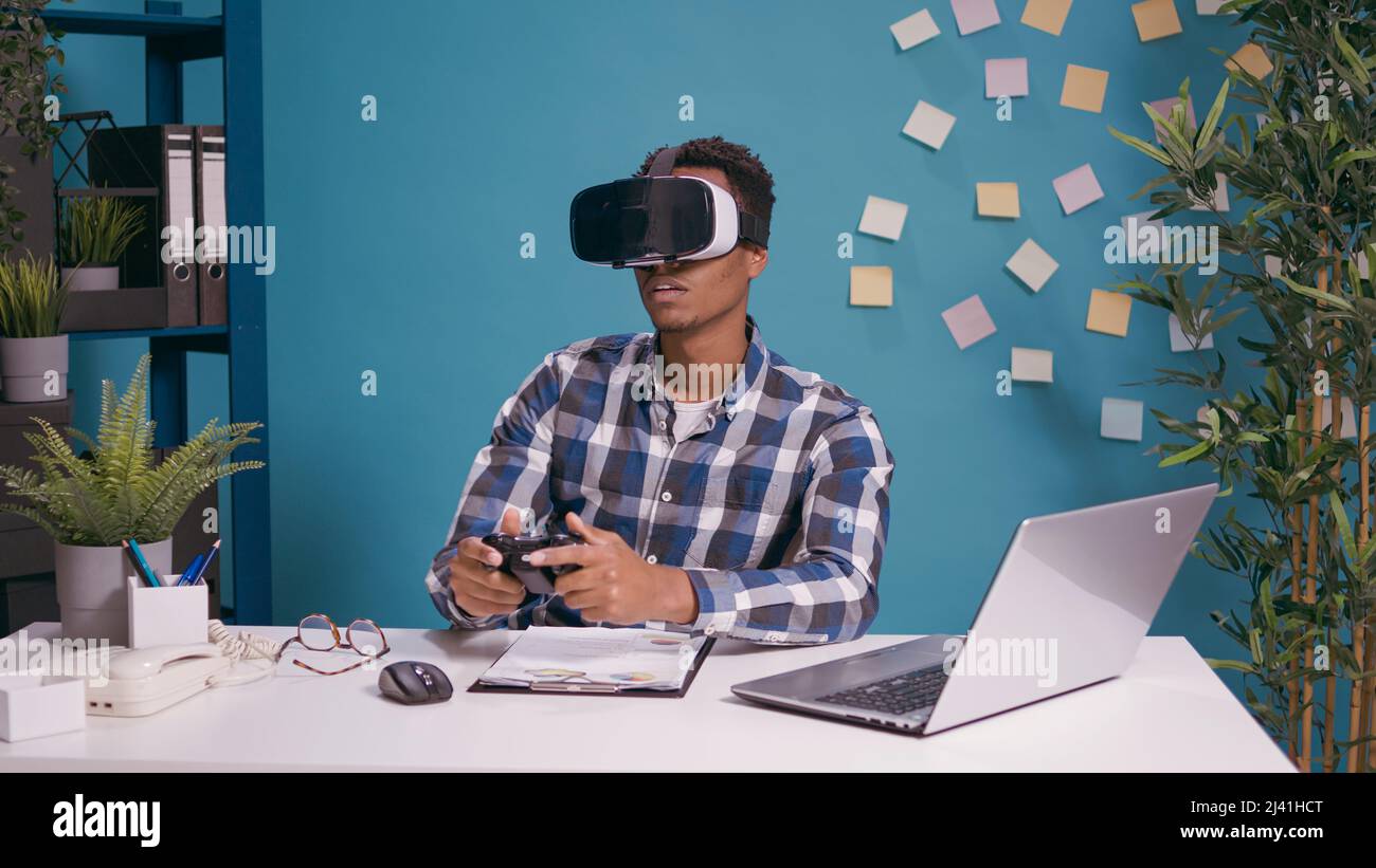 Homme moderne jouant à des jeux vidéo sur des lunettes vr et une console,  utilisant le casque et la manette de réalité virtuelle pour le plaisir.  Personne profitant de 3D lunettes de