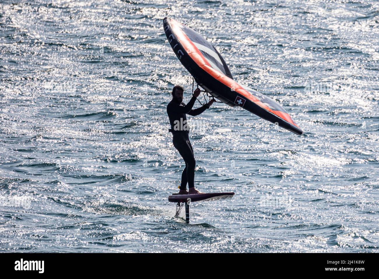 Sailor Hydro qui traverse Mounts Bay, Cornwall, sur une planche équipée d'une feuille d'aluminium.- photographiée depuis l'espace public Banque D'Images