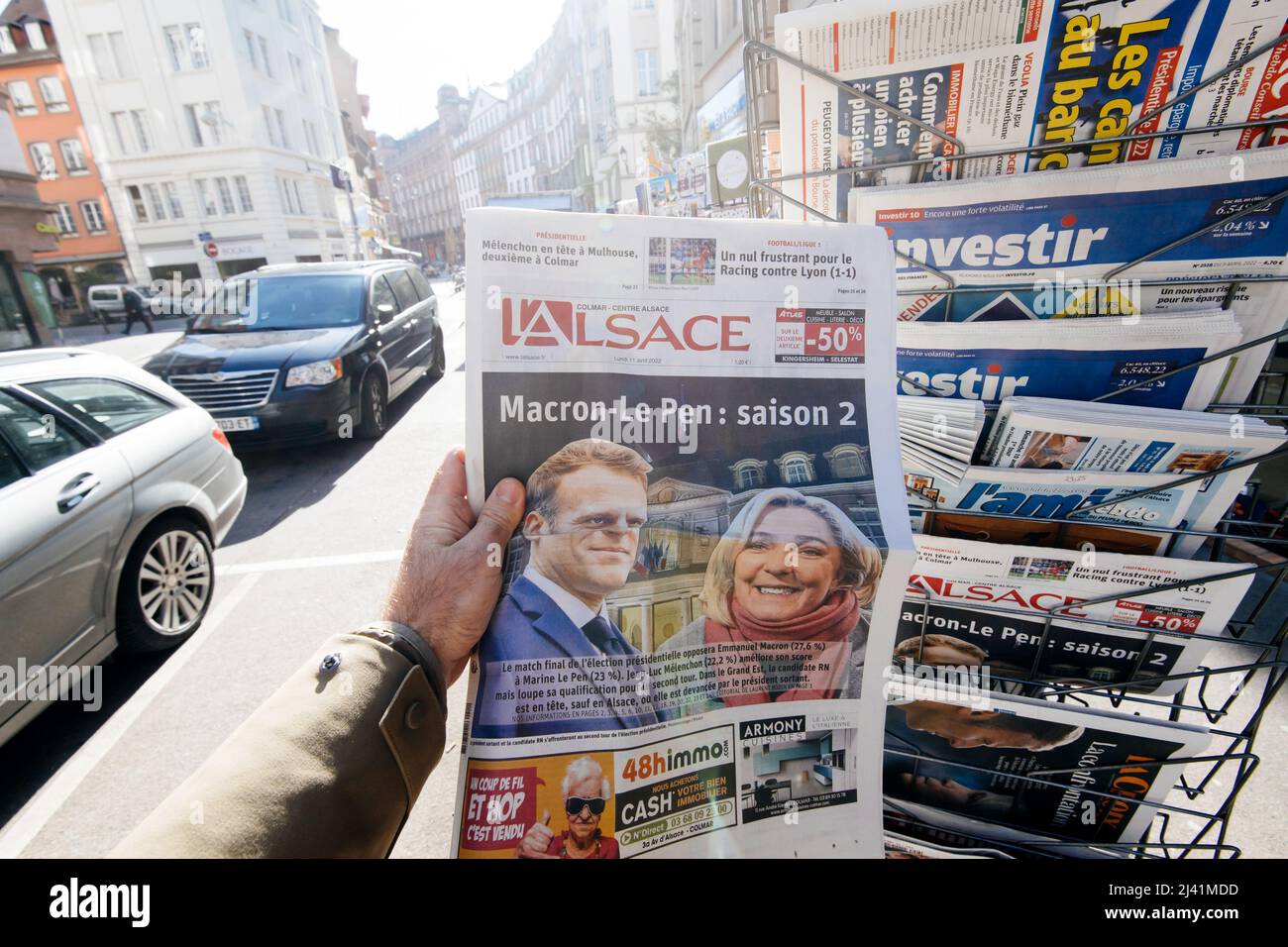 Paris, France - 11 avril : un homme en train de lire regarde le kiosque de presse du journal l'Alsace Emmanuel Macron, Marine le Pen un jour après le premier tour de l'élection présidentielle française du 10 2022 avril - titre de saison 2 Banque D'Images