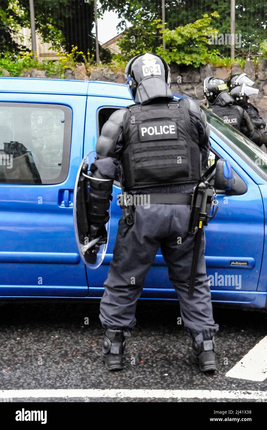 Belfast, Irlande du Nord. 21/06/2013. Un policier vêtu de matériel anti-émeute avec un bouclier arrête un véhicule Banque D'Images