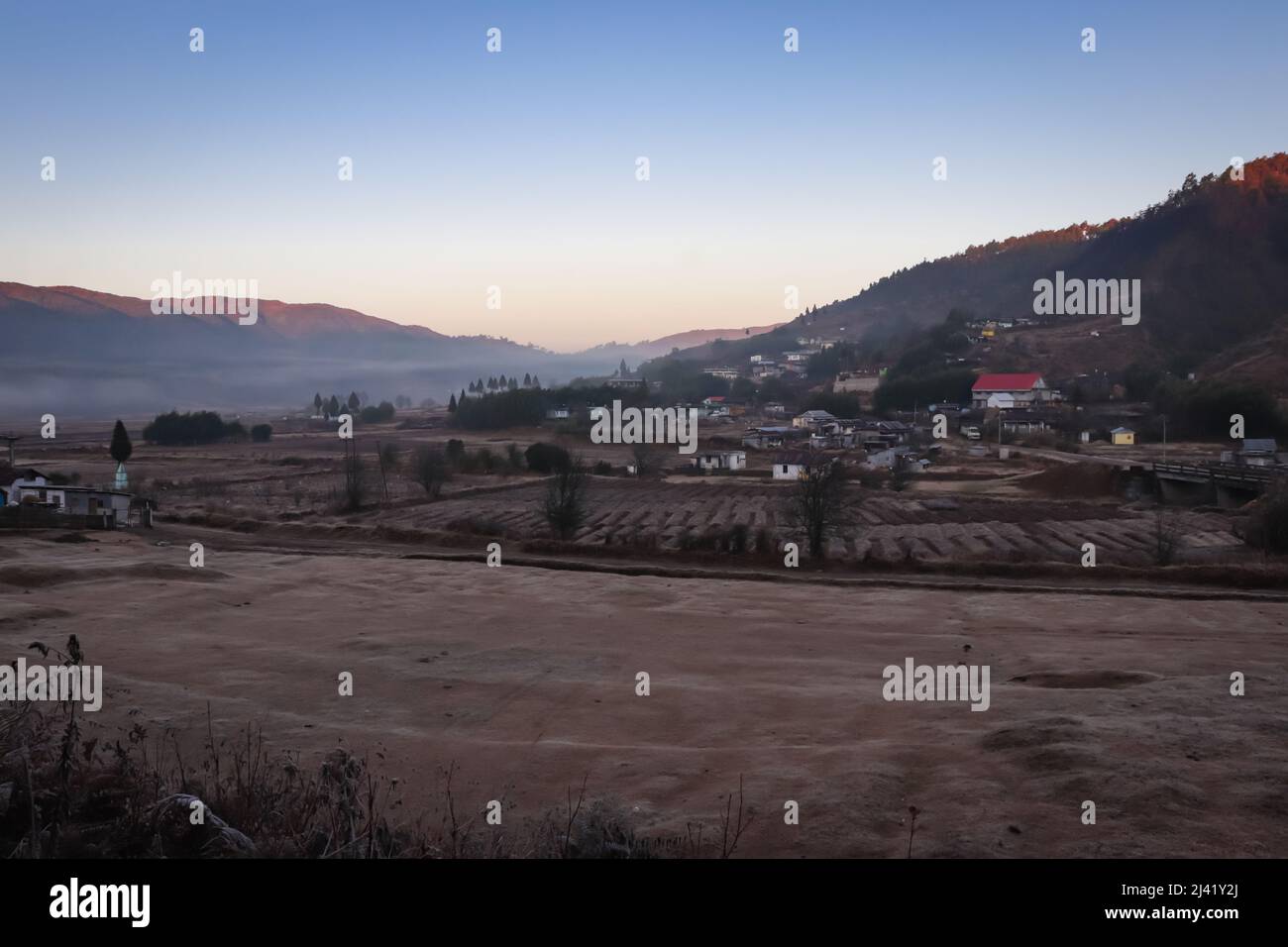 petit village aux contreforts de montagne couvert de brume blanche et ciel spectaculaire au lever du soleil image est prise à nongnah meghalaya inde. Banque D'Images