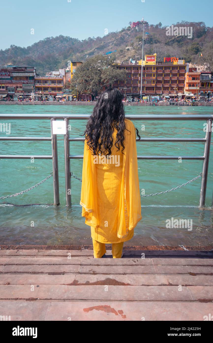 une jeune fille isolée en train de fouler le fleuve saint gange à la rive de la rivière de l'image d'angle plat est prise à la rive de la rivière ganga haridwar uttrakhet inde. Banque D'Images