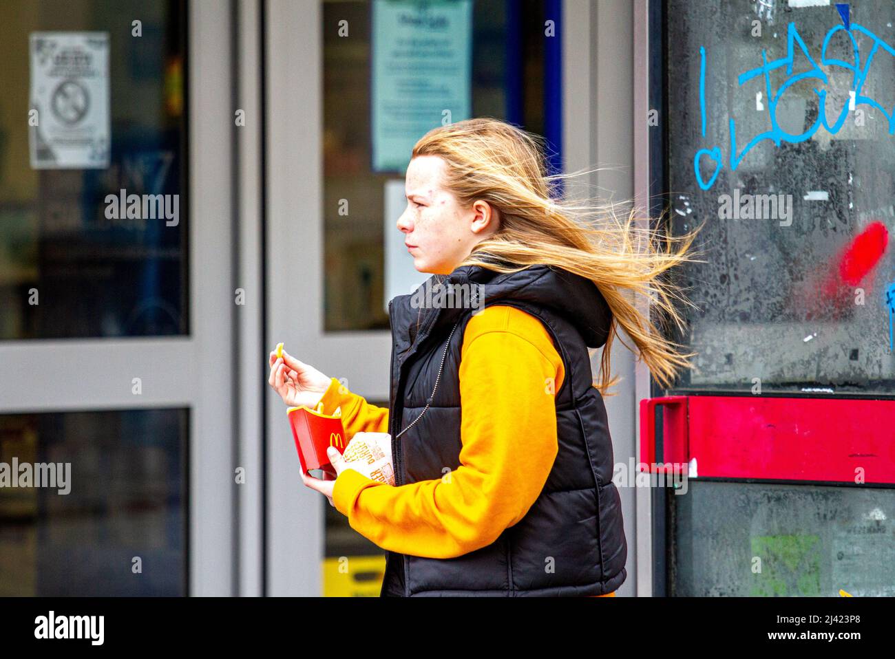 Dundee, Tayside, Écosse, Royaume-Uni. 11th avril 2022. Météo au Royaume-Uni : les températures dans le nord-est de l'Écosse ont atteint 9 °C en raison des vents d'ouest froids et violents. Les habitants de la région sont en plein centre-ville de Dundee, bravant le temps froid et venteux du printemps tout en socialisant, mais les cheveux d'une jeune femme soufflent dans le vent, ce qui la fait avoir une mauvaise journée de cheveux. Crédit : Dundee Photographics/Alamy Live News Banque D'Images