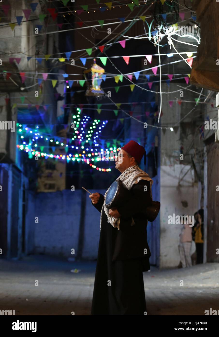 Gaza. 11th avril 2022. Un Misaharaty appelle les musulmans à prendre leur repas avant l'aube avant de commencer leur jeûne d'une journée pendant le mois Saint du Ramadan, dans la ville de Khan Younis, dans le sud de la bande de Gaza, le 11 avril 2022. Al-Misaharaty est le nom donné à la personne qui marche et bat un tambour dans les zones résidentielles pour réveiller les gens jusqu'à manger leur suhur - dernier repas avant le jeûne pendant le Ramadan. Credit: Yasser Qudih/Xinhua/Alay Live News Banque D'Images