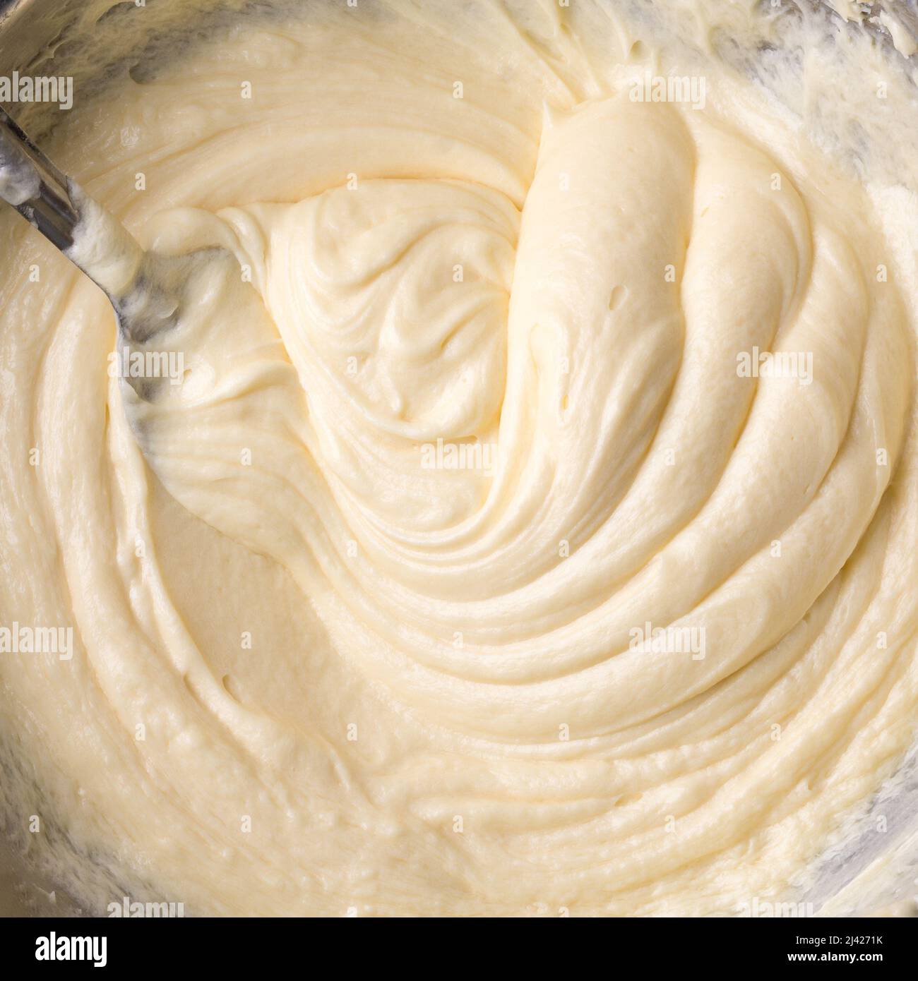 crème au beurre blanc, pâte à battre avec une cuillère, gâteau à la crème de gros plan, pris d'en haut, fond de nourriture Banque D'Images