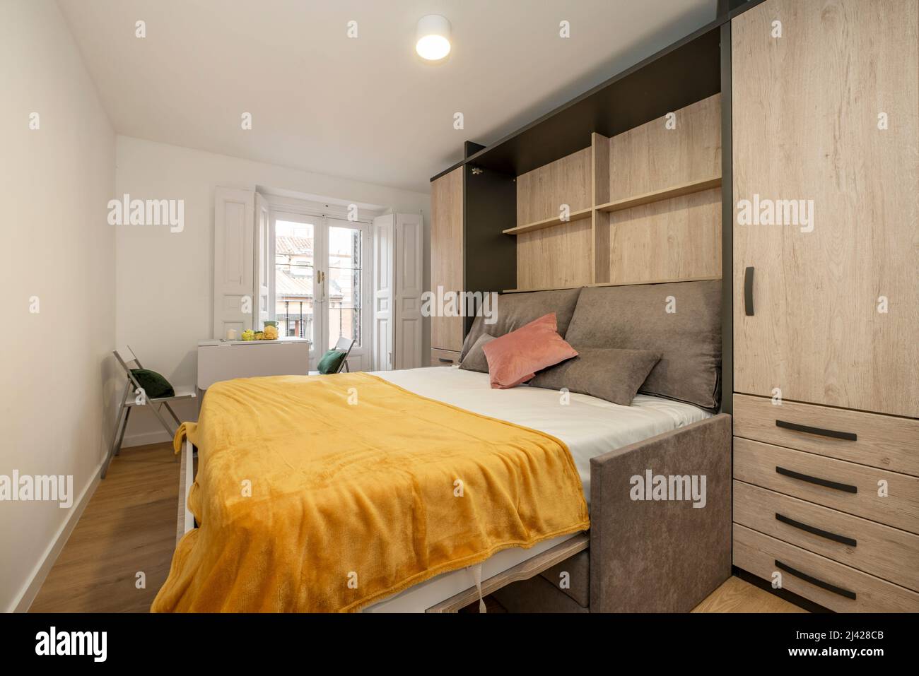 Chaise en bois à côté d'un lit double dans la chambre à coucher moderne  Photo Stock - Alamy