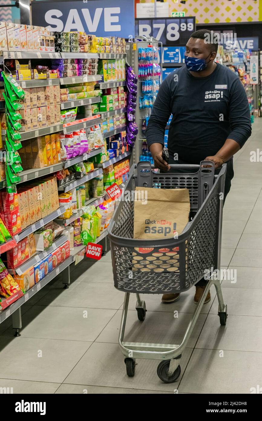 Cape Town, Afrique du Sud - 9 septembre 2021 : un membre du personnel cueille des produits à partir de l'étagère pour un service de livraison express à domicile Banque D'Images
