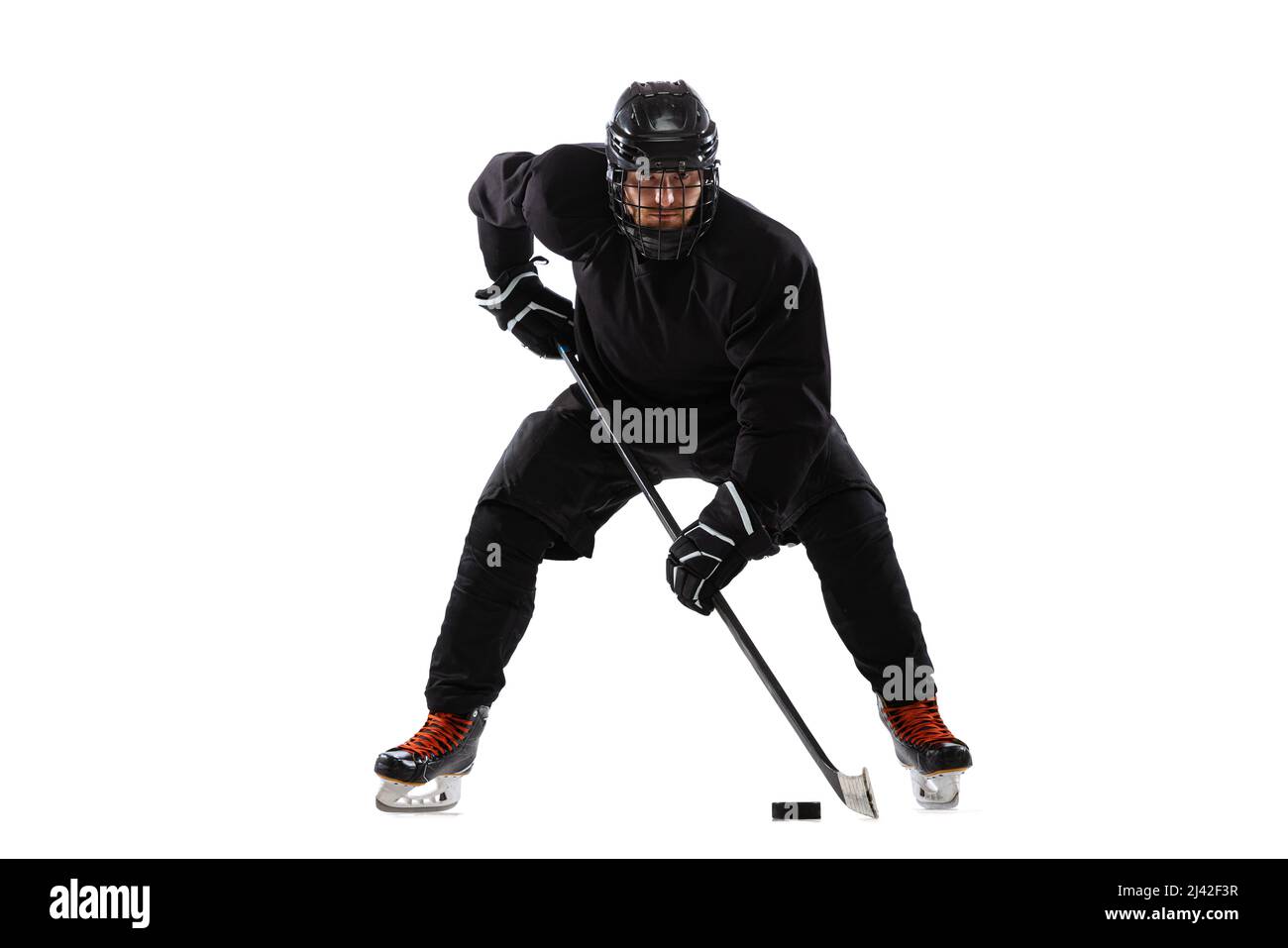 Joueur de hockey masculin avec bâton sur cour de glace et fond blanc. Entraînement actif Banque D'Images