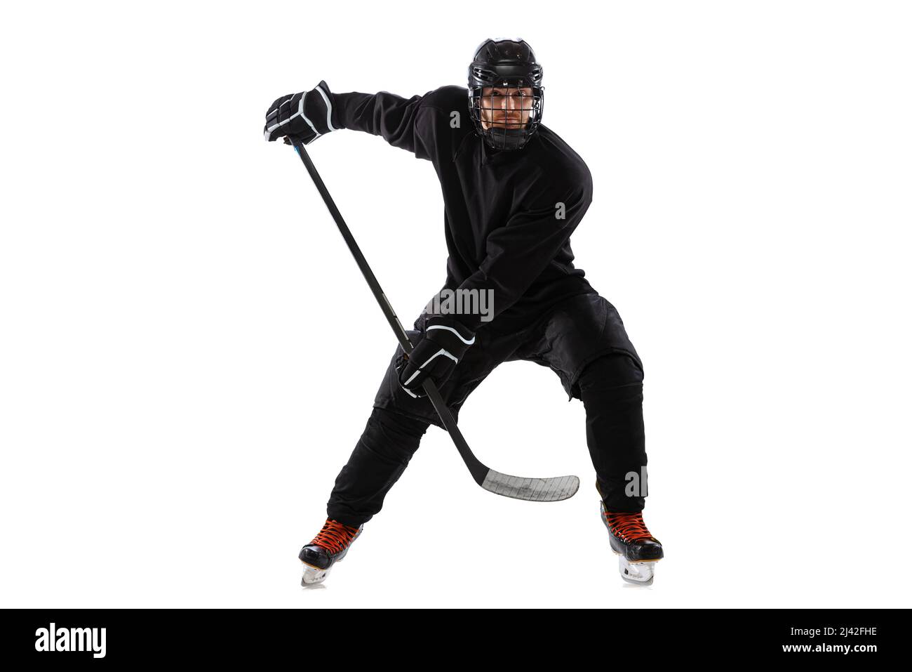 Sur la course. Joueur de hockey masculin avec bâton sur cour de glace et fond blanc. Banque D'Images