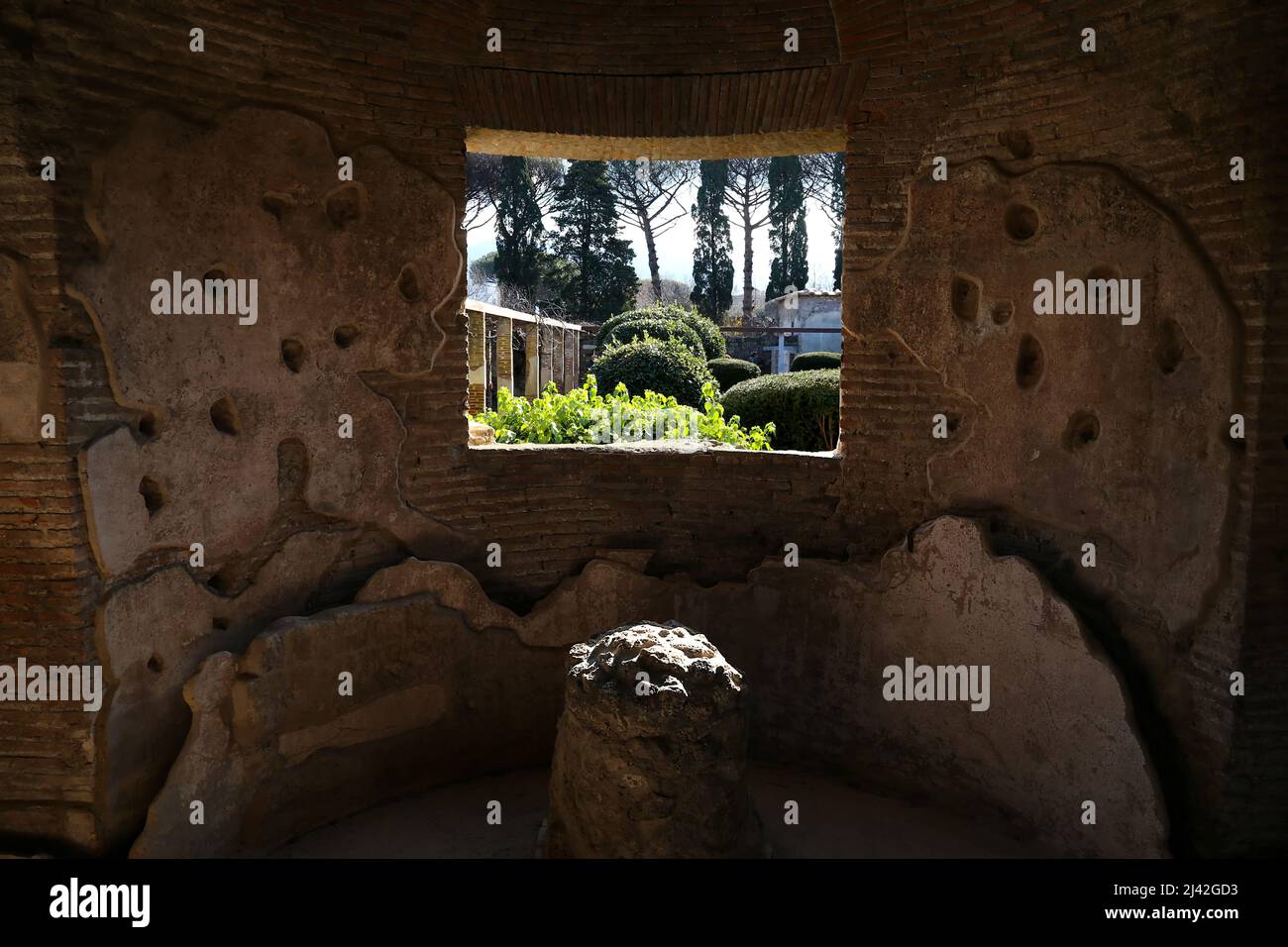 Pompéi. Italie. 5 janvier 2020. Vue sur un jardin depuis une fenêtre dans le mur en pierre d'une ancienne maison de Pompéi. C'était une ancienne ville romaine dans la sout Banque D'Images