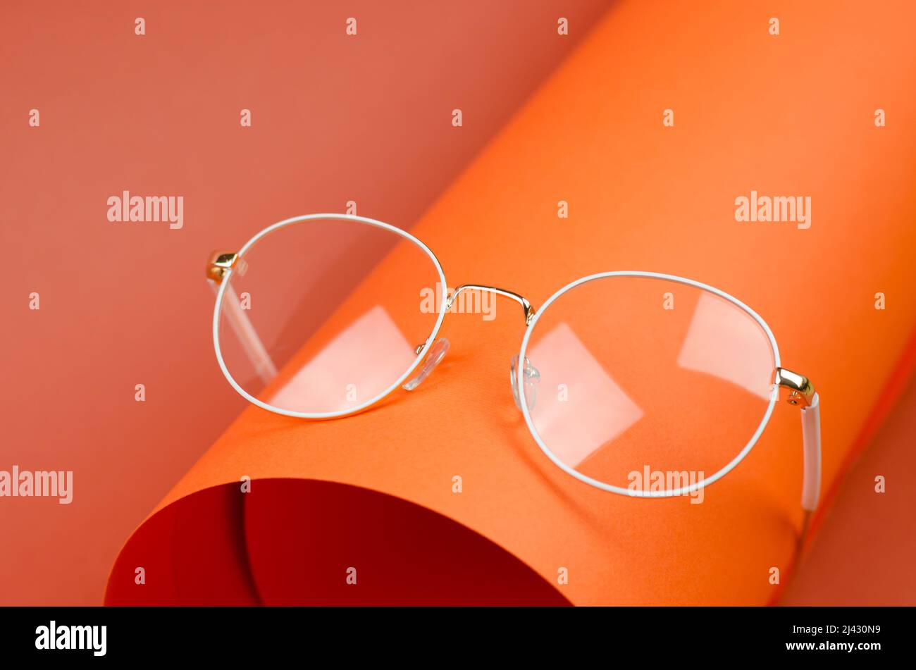 Lunettes élégantes pour femmes avec cadre blanc sur fond orange Banque D'Images