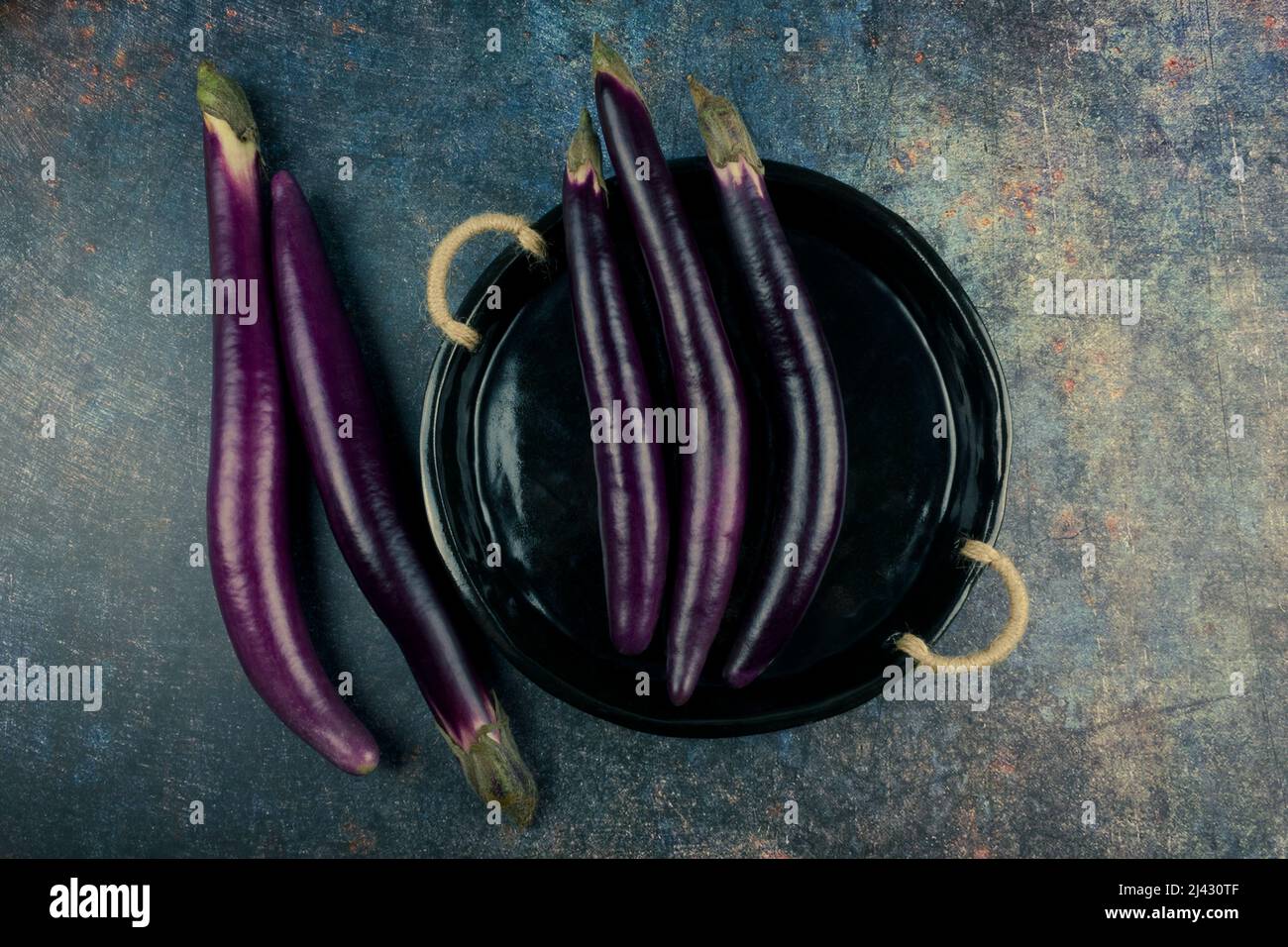 Aubergines. Aubergines fraîches bio sur l'assiette, mettre sur une table rustique. Pose à plat. Espace libre pour le texte. Banque D'Images